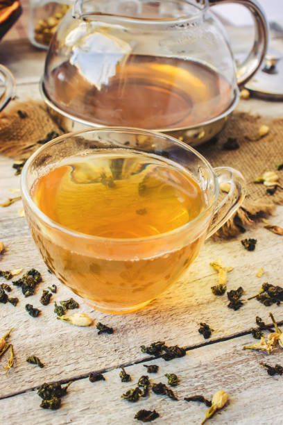 istock Green tea with Jasmine and black with transparent lemon in a small Cup on a light background. The tea maker. Selective focus. 1046599404