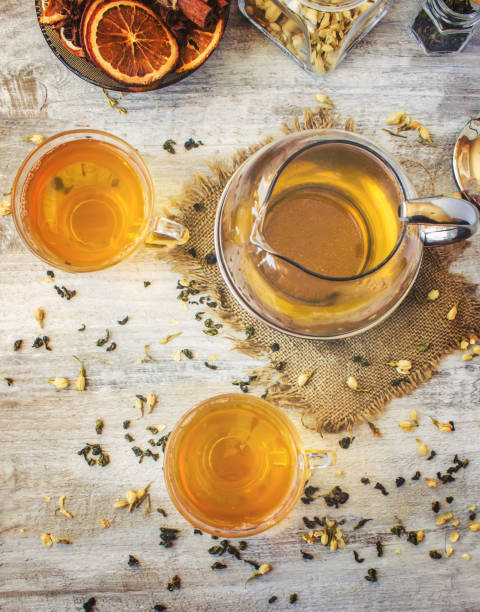 istock Green tea with Jasmine and black with transparent lemon in a small Cup on a light background. The tea maker. Selective focus. 1046599412