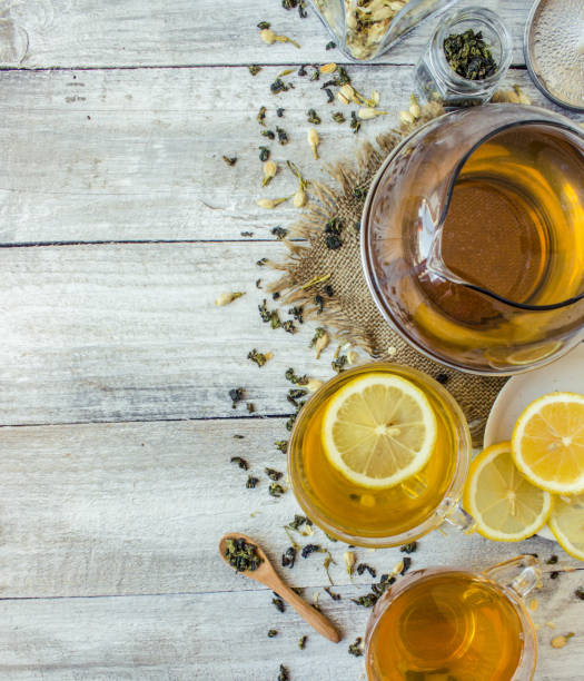 istock Green tea with Jasmine and black with transparent lemon in a small Cup on a light background. The tea maker. Selective focus. 1046599474