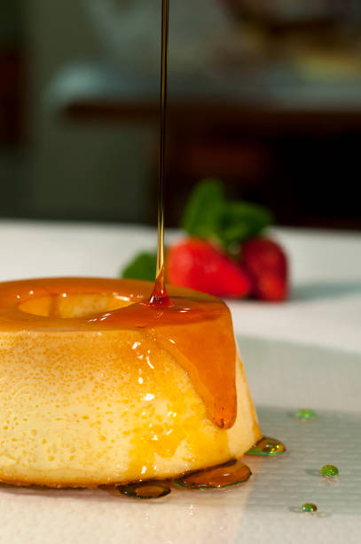 istock Milk pudding with caramel syrup and strawberries in the background 1046610212