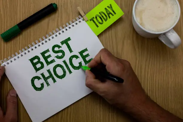 Photo of Conceptual hand writing showing Best Choice. Business photo showcasing act of picking or deciding between two or more possibilities Man holding marker notebook reminder wooden table cup coffee.