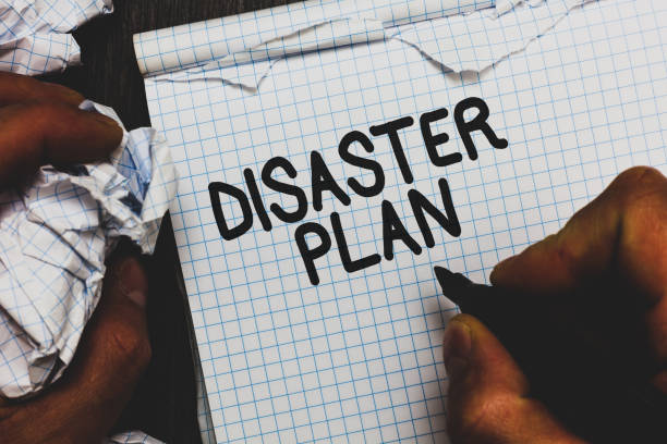 istock Handwriting text Disaster Plan. Concept meaning Respond to Emergency Preparedness Survival and First Aid Kit Man holding marker notebook crumpled papers ripped pages mistakes made. 1046617124
