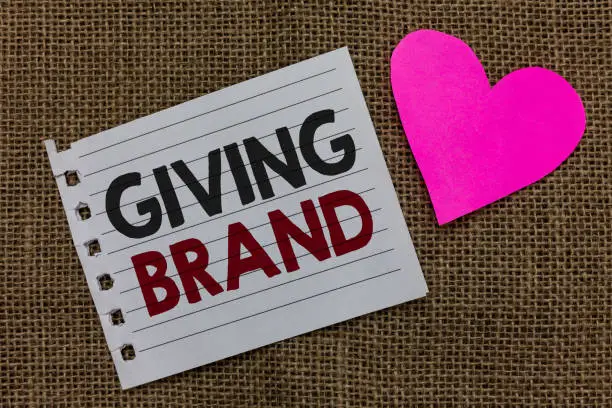 Photo of Conceptual hand writing showing Giving Brand. Business photo text The process of giving a Name to a company products or services Piece paper Romantic ideas Communicate feelings Jute background.