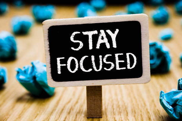 istock Handwriting text Stay Focused. Concept meaning Be attentive Concentrate Prioritize the task Avoid distractions Blackboard crumpled papers several tries mistake not satisfied wooden floor. 1046618852