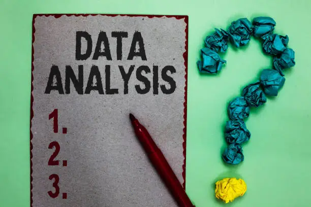 Photo of Handwriting text writing Data Analysis. Concept meaning Translate numbers to Analytical Conclusion Forecasting Gray paper marker crumpled papers forming question mark green background.