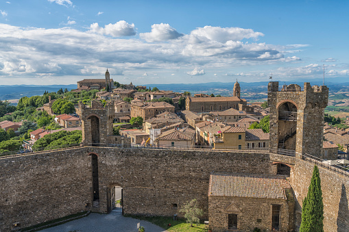 View from fortress with fortified wall on town of Montalcino in Italy against clear blue sky on sunny day.