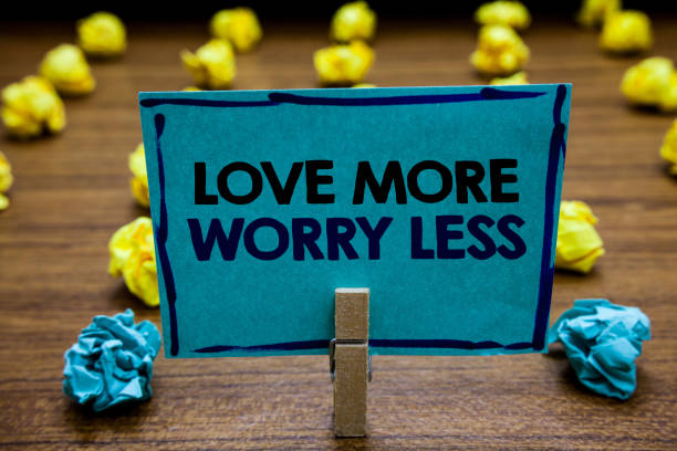 istock Handwriting text Love More Worry Less. Concept meaning Have a good attitude motivation be lovable enjoy life Blurry wooden deck yellow and blue lob on ground paper clip grip page with text. 1046620478