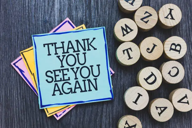 Handwriting text Thank You See You Again. Concept meaning Appreciation Gratitude Thanks I will be back soon Black wooden deck written sticky note beside some round woody alphabets