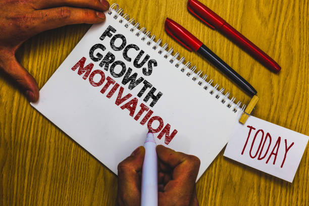 istock Writing note showing Focus Growth Motivation. Business photo showcasing doing something with accuracy increase productivity Man holding marker notebook clothepin reminder wooden table cup coffee. 1046623102