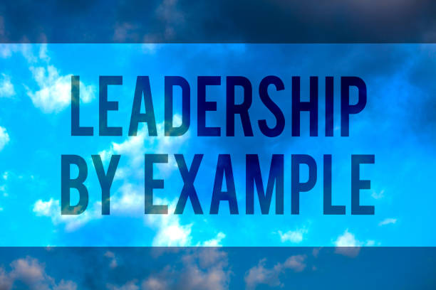 istock Handwriting text Leadership By Example. Concept meaning Becoming role model for people Have great qualities Multiline text desktop natural blue sky cloudy background send messages. 1046623152