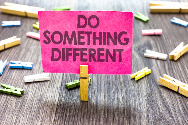 Writing note showing Do Something Different. Business photo showcasing be unique Think outside of the box Have some fun Multiple clips woody table small card clipped notice announcement.