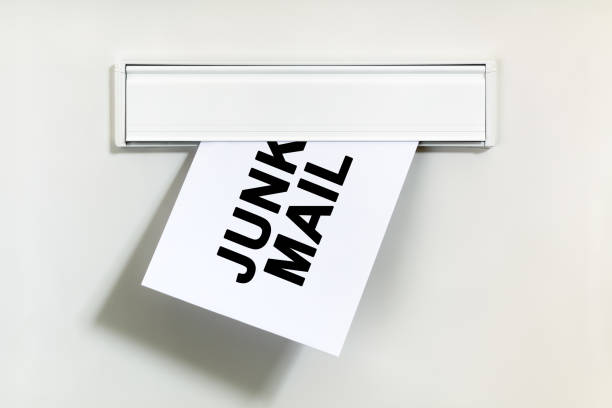 Junk mail or spam through the letterbox Junk mail or spam on letter being delivered through a letterbox concept for unsolicited mail or e-mail junk mail photos stock pictures, royalty-free photos & images
