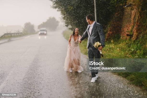 Nur Verheiratete Paar Hand In Hand Und Fuß Auf Regen Wandern In Nasse Zeremonielle Kleidung Antrieb Unterwegs Lächeln Und Spaß Stockfoto und mehr Bilder von Hochzeit