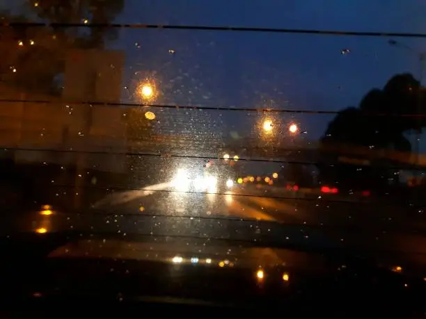 A car window and street during a raining night