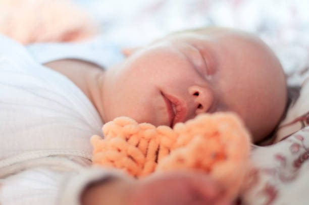 istock A tiny newborn baby is sleeping on the bed. Baby. 1046634558