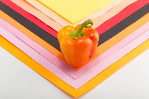 Sweet bell pepper. Yellow-orange sweet bellpepper on a colorful background. One. Pattern. Studio light. Top view