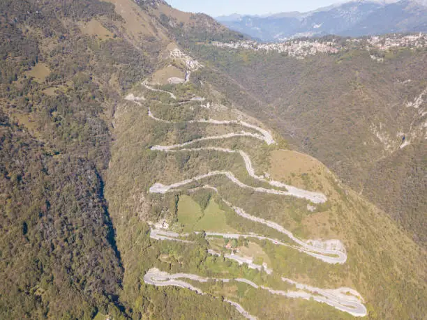 Photo of Drone aerial view of the mountain road in Italy that connects the village of Nebro to Selvino. Amazing aerial view of the mountain bends creating beautiful shapes