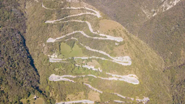 Photo of Drone aerial view of the mountain road in Italy that connects the village of Nebro to Selvino. Amazing aerial view of the mountain bends creating beautiful shapes