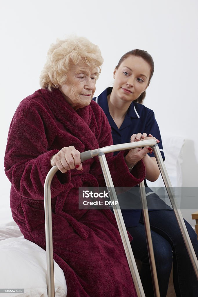 Pielęgniarka pomaga Starsza kobieta chodzić z ramą - Zbiór zdjęć royalty-free (Dom pomocy)