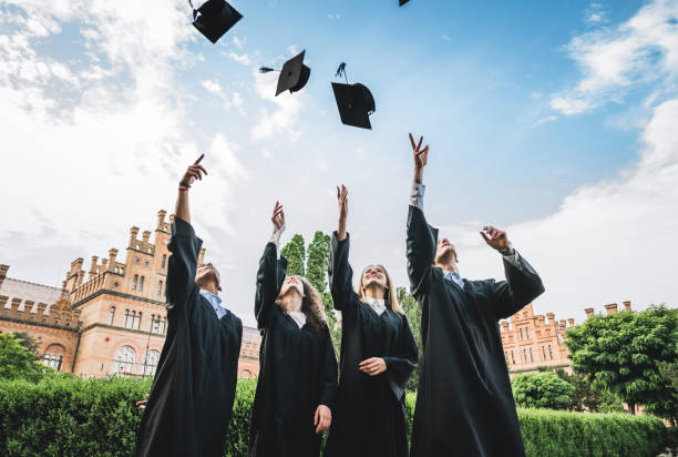 We've finally graduated! We've finally graduated!Graduates near university are throwing up hats in the air. cape garment photos stock pictures, royalty-free photos & images