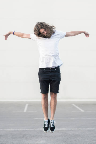 Young man in a Jesus Christ suspended pose concept Young man in a Jesus Christ suspended pose concept levitation stock pictures, royalty-free photos & images