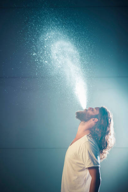 istock Young man blowing water from mouth side shot 1046687794