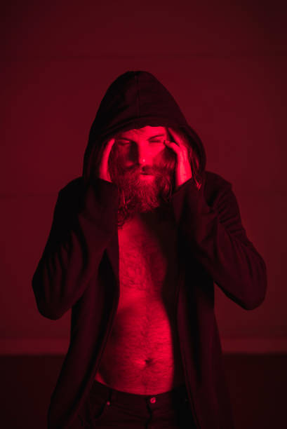 istock Man in red light holding his head 1046687862