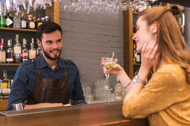 istock Friendly barman looking at the drinking visitor and smiling 1046688376