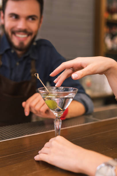 istock Young barman smiling and the client touching the glass 1046688378