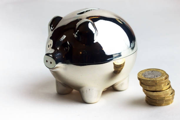 piggy bank com moedas - piggy bank gold british currency pound symbol - fotografias e filmes do acervo