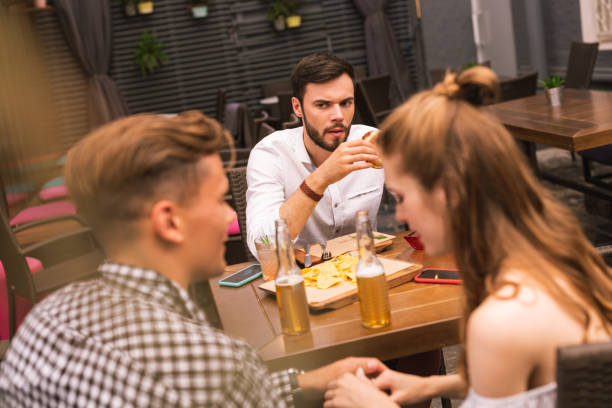 istock Young man having strange feeling while seeing his friends flirting 1046694208