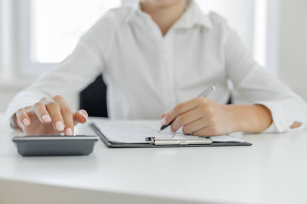 istock Woman considers on calculator in office 1046702898