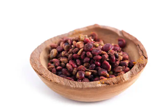 Wooden bowl with sumac on white background