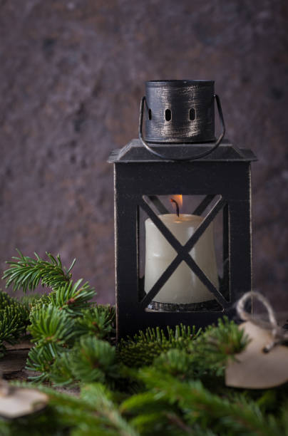 istock Christmas composition with candle lantern and fir dark background 1046732982