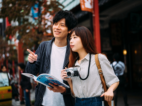 A young Chinese couple enjoys a vacation in Tokyo, Japan by exploring the traditional Asakusa area of the city.