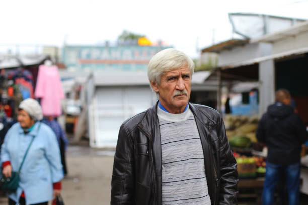 portrait of a man 60 years old. The man is on the street at the grocery store