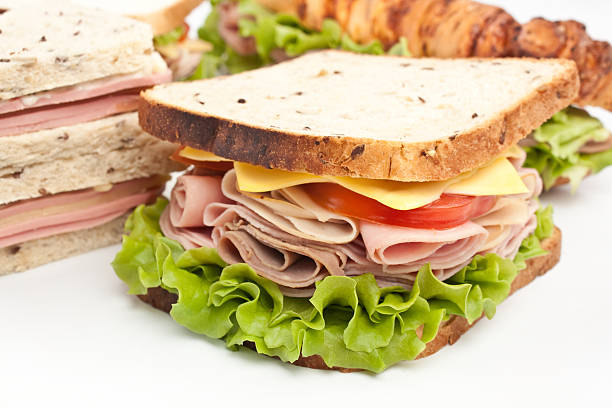 Sandwich made of tomato,ham,swiss cheese and lettuce.
