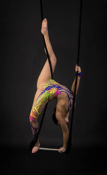 istock A young girl performs the acrobatic elements in the air trapeze. 1046765250
