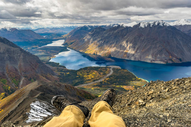 Adventure concept, resting male legs in front of the stunning landscape. Yukon, Canada stock photo