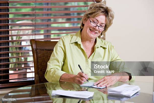 Szczęśliwy Starsza Kobieta Pisanie Sprawdzić Płacenie Rachunków W Domu - zdjęcia stockowe i więcej obrazów Czek