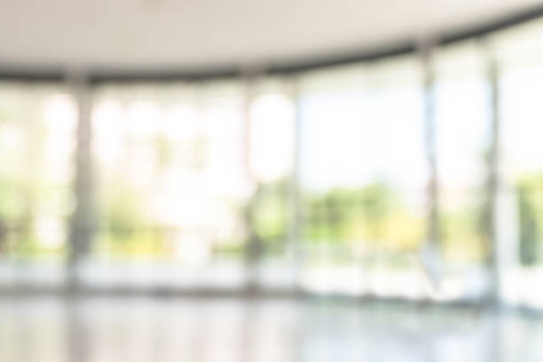 istock Blur background interior view looking out toward to empty office lobby and entrance doors and glass curtain wall 1046786676