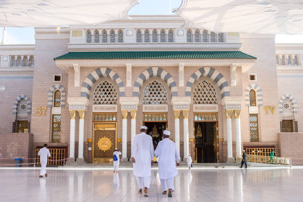 Al-Masjid Al-Nabawi or Prophet Muhammed Mosque Prayers walking in the entrance gate of Al-Masjid Al-Nabawi or Prophet Muhammed Mosque, the most beautiful mosque in the world, located in City of Medina oracle building stock pictures, royalty-free photos & images
