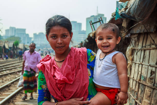 Bangladesh woman Unidentified poor Bangladeshi woman holding her child in arms in a poor slum area near railways bangladesh photos stock pictures, royalty-free photos & images