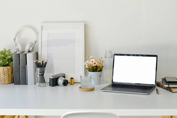 istock Creative workspace mock up laptop blank screen in modern home office interior with office supplies on white wooden desk, 1046807846
