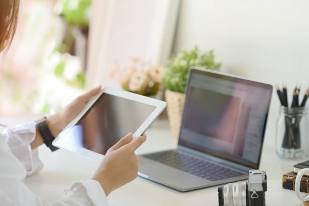 istock Unrecognizable businesswoman using a tablet on desk 1046807910
