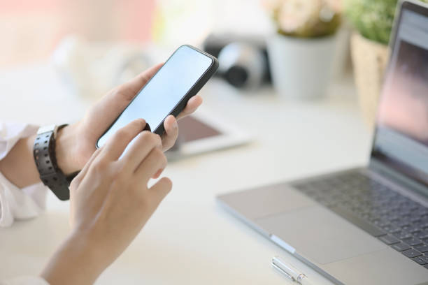 istock Unrecognizable businesswoman using a mobile phone on desk 1046807930