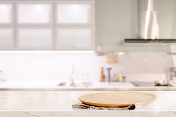 istock Empty wood plate on marble counter over kitchen room. 1046808136