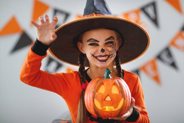 ハロウィンにカボチャの衣装で幸せな子供女の子 - pumpkin small orange holiday ストックフォトと画像