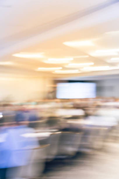istock Blurry background speaker on conference stage with projector in America 1046832584