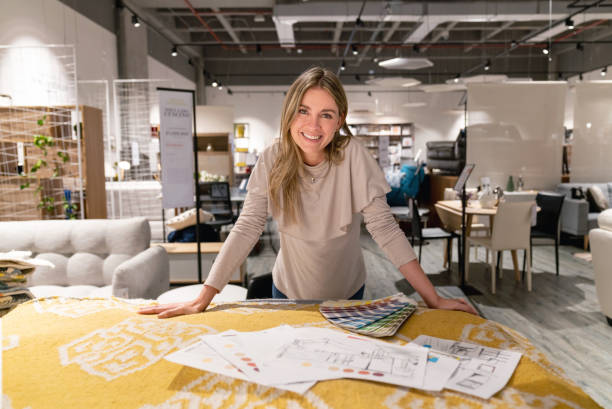 Interior designer working on home design at a furniture store Portrait of a happy interior designer working on a home design at a furniture store and looking at the camera smiling. **DESIGN ON SKETCH WAS MADE FROM SCRATCH BY US** showroom stock pictures, royalty-free photos & images